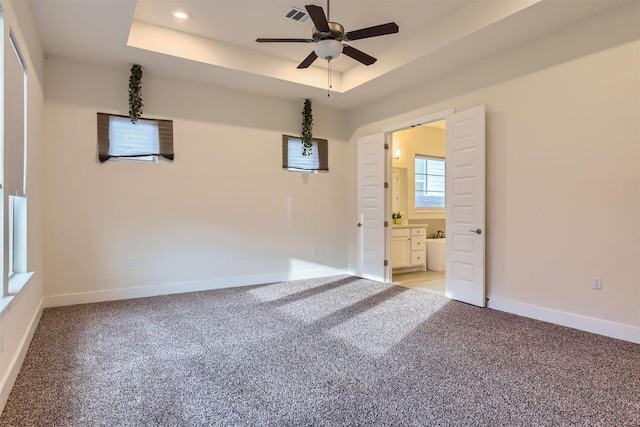 spare room featuring recessed lighting, a raised ceiling, visible vents, light carpet, and baseboards