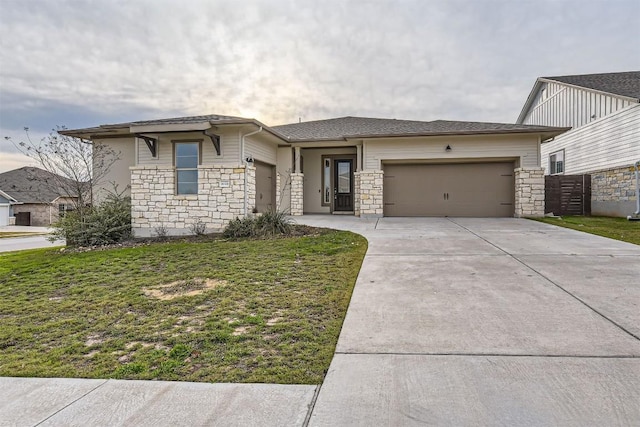 prairie-style home with a garage, concrete driveway, a front lawn, and stone siding