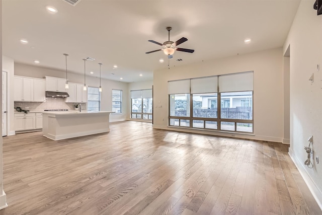 unfurnished living room featuring ceiling fan and light hardwood / wood-style flooring