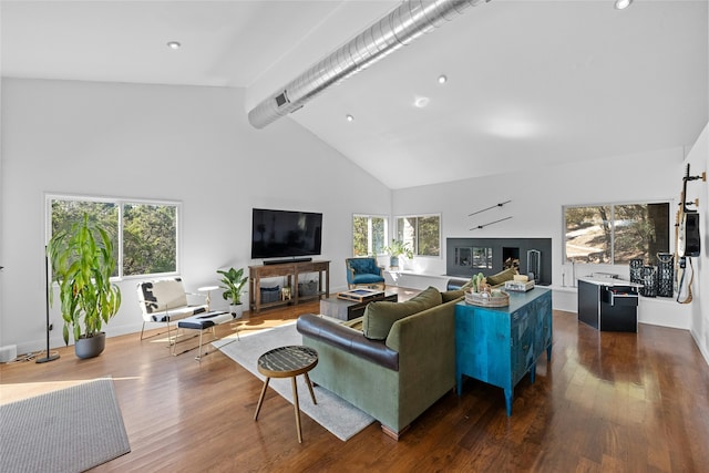 living room with beamed ceiling, high vaulted ceiling, a healthy amount of sunlight, and dark hardwood / wood-style floors