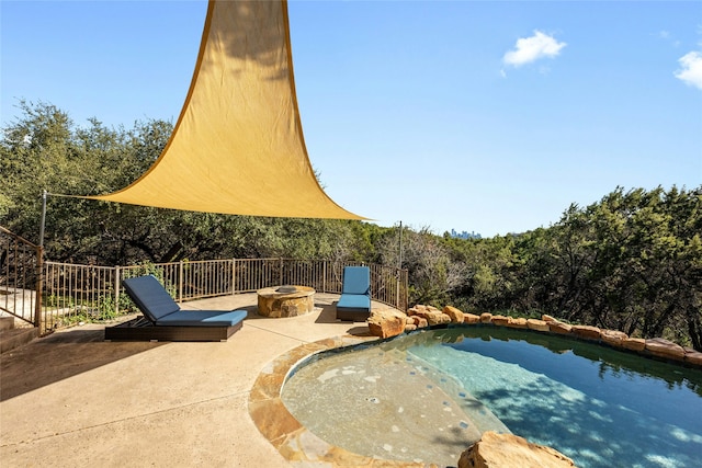 view of patio / terrace featuring a fenced in pool and a fire pit