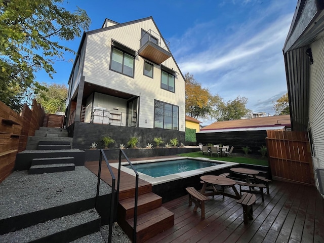 rear view of property with a pool side deck