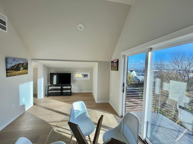 living room featuring lofted ceiling, light hardwood / wood-style floors, and plenty of natural light