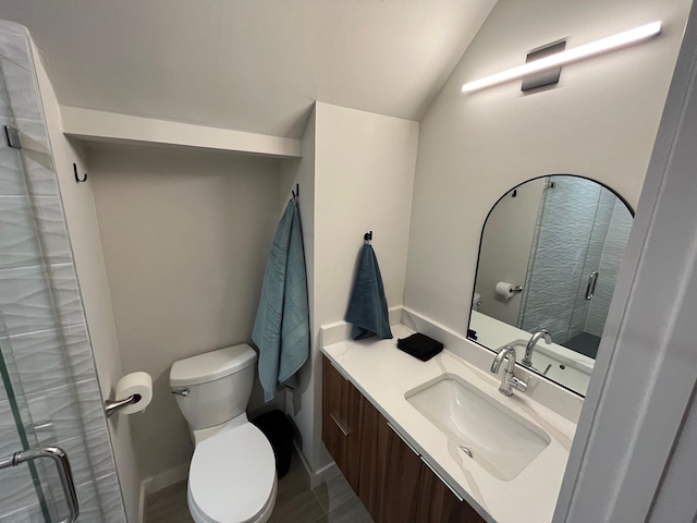 bathroom featuring toilet, vanity, lofted ceiling, and walk in shower