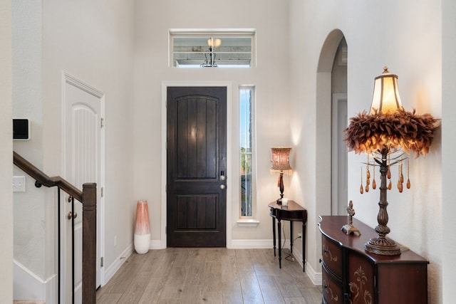 17820 Limestone Spring Ln, Austin, TX 78738 - entryway with wood finished floors, arched walkways, baseboards, a towering ceiling, and stairs