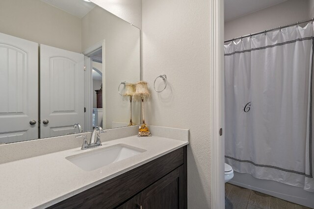 17820 Limestone Spring Ln, Austin, TX 78738 - full bath featuring vanity, toilet, wood finished floors, and shower / bathtub combination with curtain