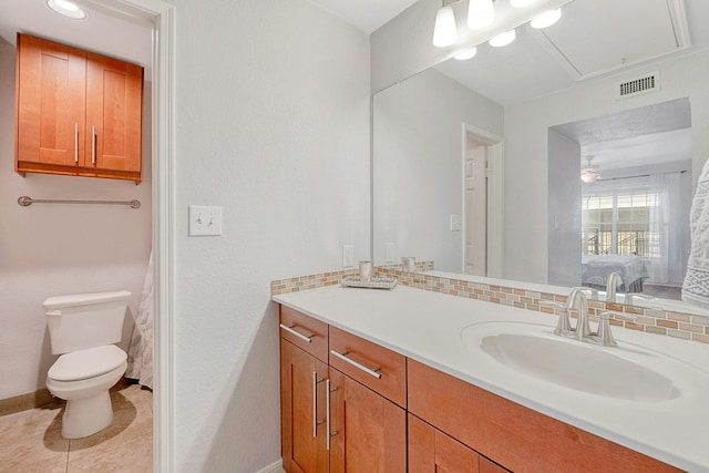 bathroom featuring toilet, ceiling fan, tasteful backsplash, and vanity