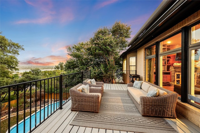 deck at dusk featuring a fenced in pool and outdoor lounge area