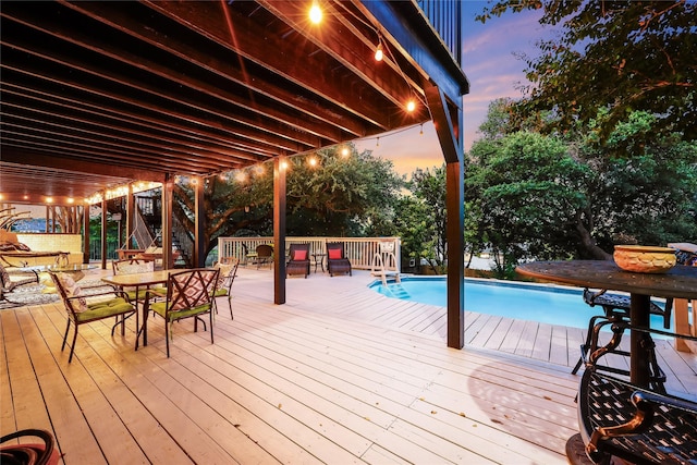 pool at dusk featuring a deck