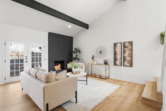 living room with a large fireplace, light hardwood / wood-style flooring, french doors, and vaulted ceiling with beams