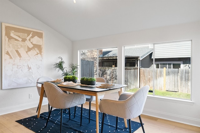 dining space with hardwood / wood-style floors and lofted ceiling