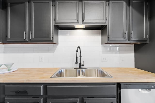 kitchen featuring stainless steel dishwasher, decorative backsplash, sink, and butcher block counters