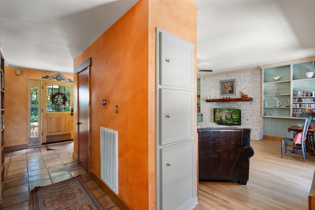 hall with built in shelves and light hardwood / wood-style floors