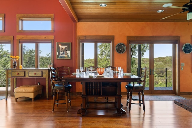 dining room featuring a healthy amount of sunlight, ceiling fan, wooden ceiling, and hardwood / wood-style flooring