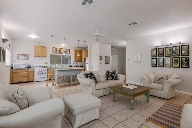 living room with ceiling fan, sink, and light tile patterned floors