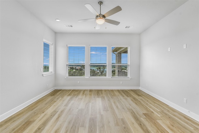 spare room with ceiling fan, light hardwood / wood-style floors, and a healthy amount of sunlight