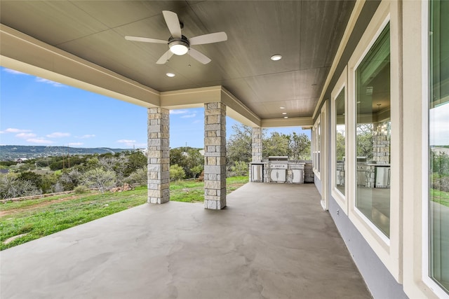 view of patio featuring exterior kitchen, ceiling fan, a mountain view, and a grill