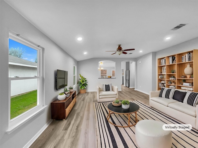 living room with ceiling fan, plenty of natural light, and light hardwood / wood-style flooring