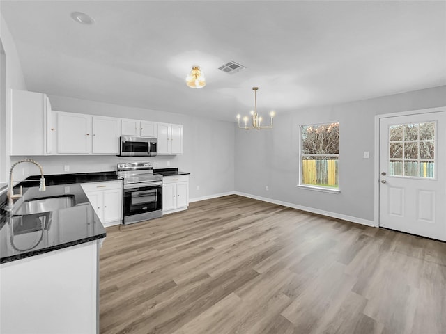 kitchen with a chandelier, decorative light fixtures, white cabinets, appliances with stainless steel finishes, and sink