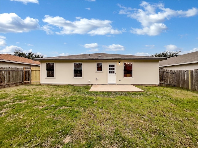 back of house with a yard and a patio