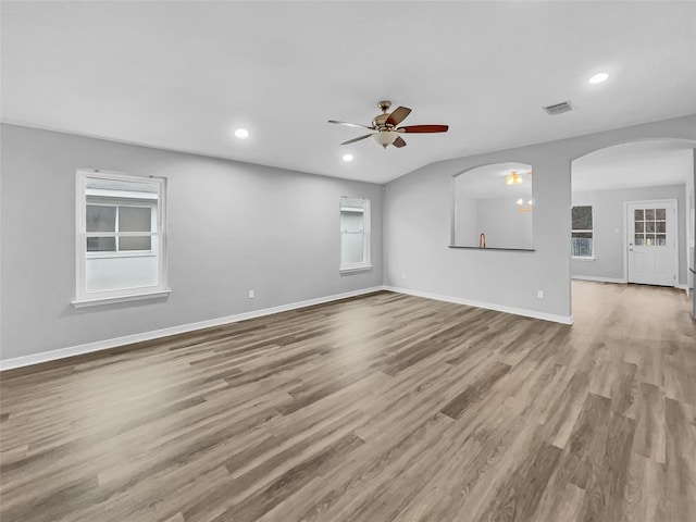 unfurnished living room featuring ceiling fan, a healthy amount of sunlight, and light wood-type flooring