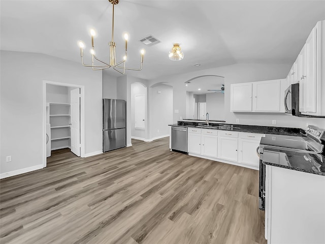 kitchen with stainless steel appliances, sink, white cabinetry, decorative light fixtures, and ceiling fan with notable chandelier