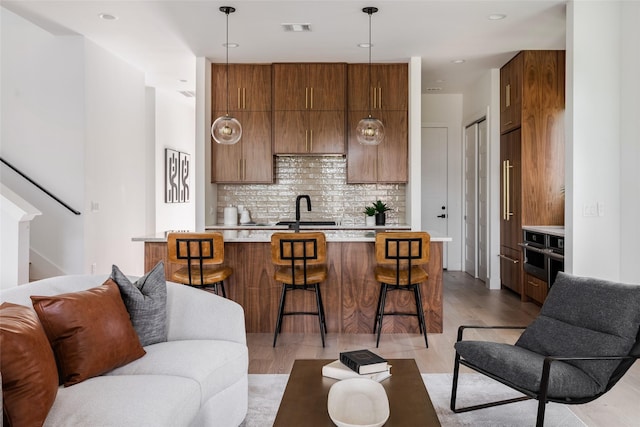 living room with sink and light wood-type flooring