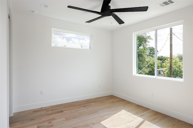 empty room with ceiling fan and light hardwood / wood-style flooring