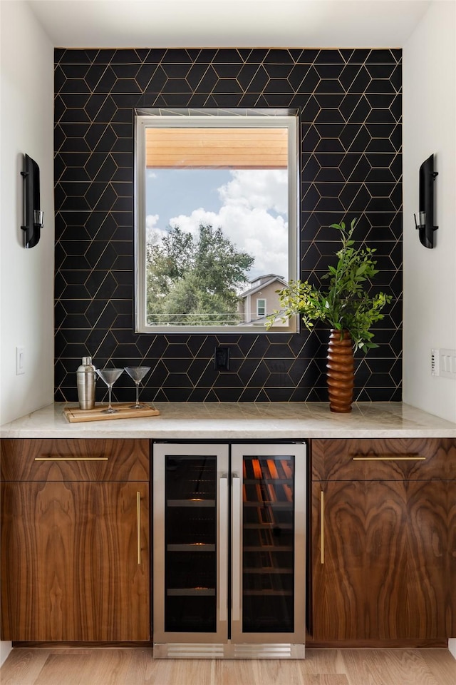 bar featuring light wood-type flooring and wine cooler