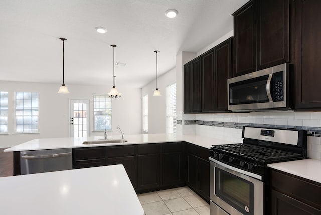 kitchen featuring kitchen peninsula, stainless steel appliances, and pendant lighting