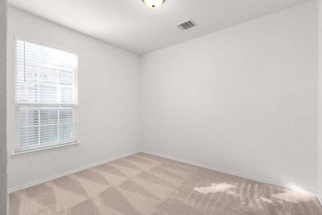 spare room featuring light carpet