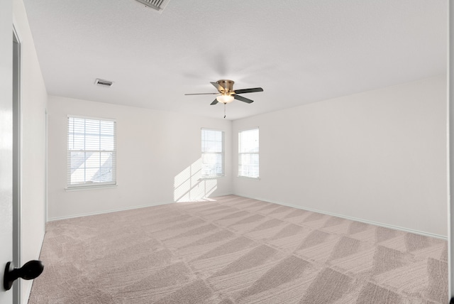 unfurnished room featuring ceiling fan and light carpet