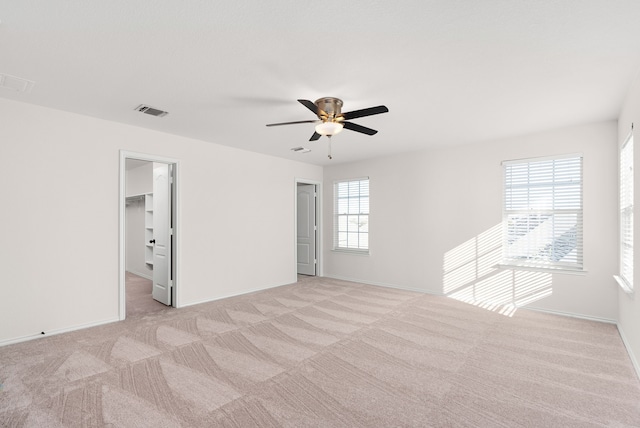 spare room featuring ceiling fan and light carpet