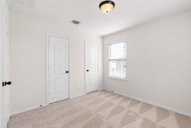 unfurnished bedroom with light colored carpet