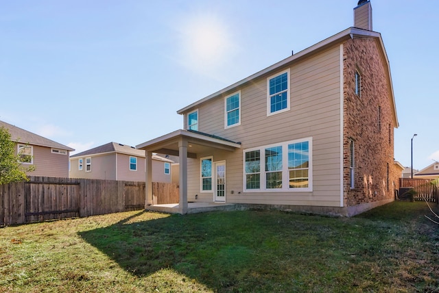 back of property featuring a patio area and a lawn