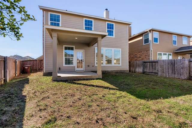 rear view of property featuring a patio and a lawn