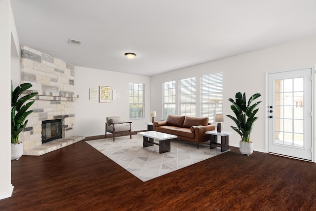 living room with light wood-type flooring and a stone fireplace