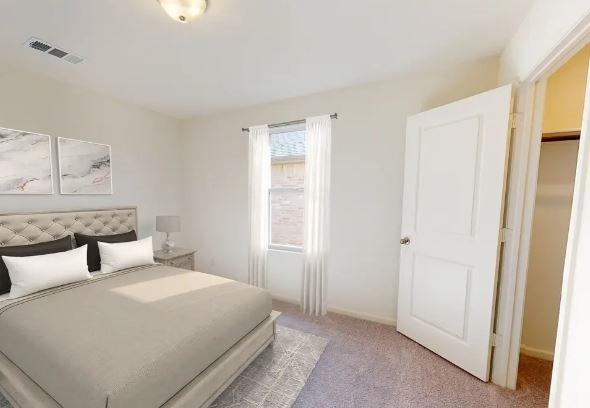 carpeted bedroom with a spacious closet