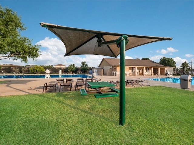 view of property's community featuring a swimming pool, a patio area, and a yard