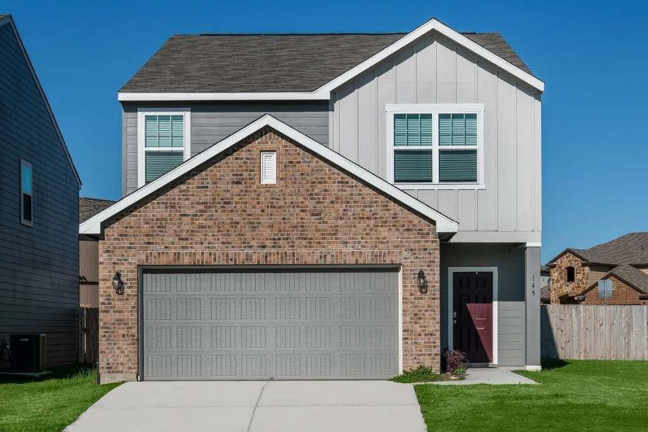 view of front of property with central AC, a garage, and a front yard