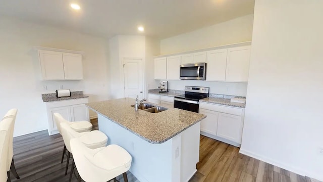 kitchen featuring white cabinets, appliances with stainless steel finishes, and a kitchen island with sink