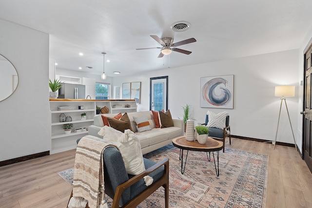 living room with ceiling fan and light hardwood / wood-style flooring