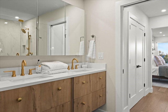 bathroom featuring hardwood / wood-style flooring, a shower, and vanity