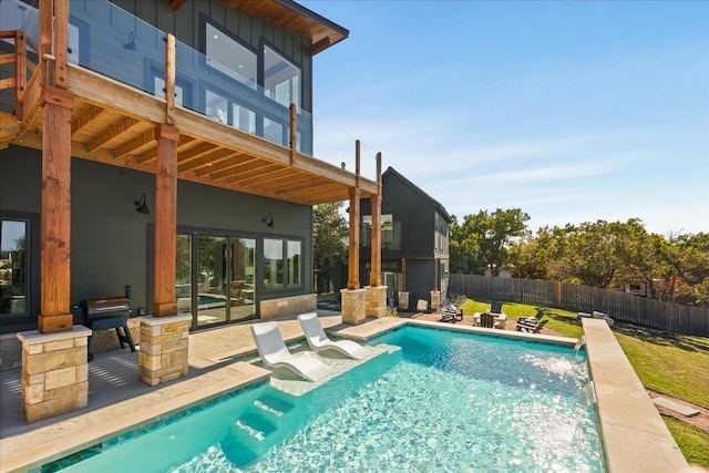 view of pool with a yard, pool water feature, and a patio area