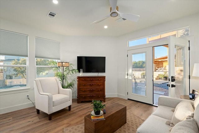 living room featuring ceiling fan and light hardwood / wood-style floors