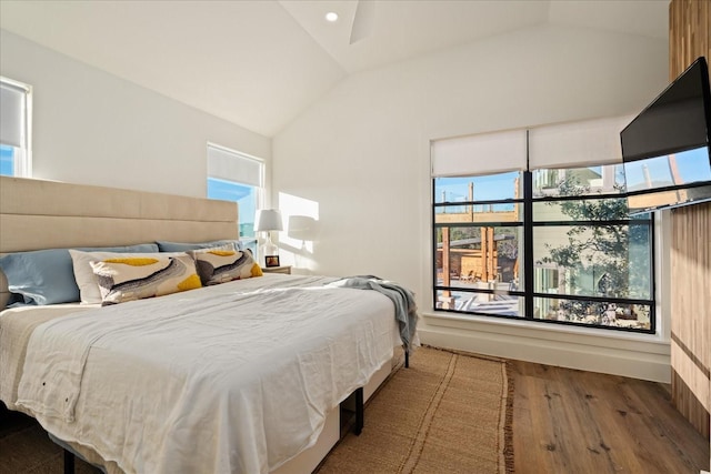 bedroom featuring hardwood / wood-style floors, multiple windows, and lofted ceiling