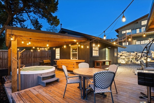 wooden terrace featuring a hot tub and a bar