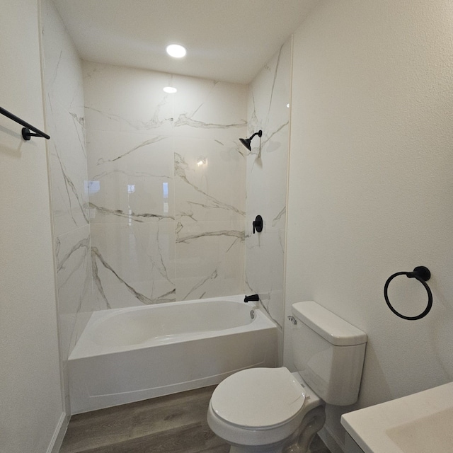 bathroom with toilet, hardwood / wood-style flooring, and tiled shower / bath combo