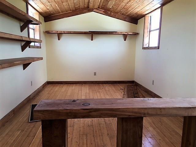 interior space with light wood-type flooring, wooden ceiling, and vaulted ceiling