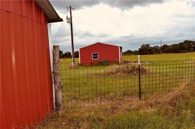 view of yard with a rural view and an outdoor structure